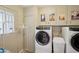 Bright laundry room featuring a washer, dryer, and vintage travel posters above the units at 10431 W Roundelay Cir, Sun City, AZ 85351