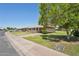 Street view showcasing a well-maintained home with mature trees and curb appeal at 10431 W Roundelay Cir, Sun City, AZ 85351