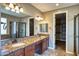Primary bathroom featuring a double sink vanity, granite countertops, and a walk-in shower and open closet at 1101 W Oleander Ave, Queen Creek, AZ 85140