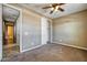 Bedroom with neutral carpet, closet, ceiling fan, and adjacent doorway at 1101 W Oleander Ave, Queen Creek, AZ 85140