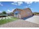 Exterior view of house with a well-maintained backyard, featuring artificial grass and desert landscaping at 1101 W Oleander Ave, Queen Creek, AZ 85140