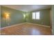 Bright bedroom featuring sleek wood-look floors and a window with stylish white shutters at 1109 N Walnut Dr, Casa Grande, AZ 85122
