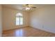 Bright bedroom featuring wood floors, fan and a large arched window at 1109 N Walnut Dr, Casa Grande, AZ 85122