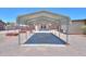 Metal carport covers a long driveway, leading to a home with a covered patio at 1109 N Walnut Dr, Casa Grande, AZ 85122