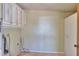 Empty laundry room featuring upper cabinets, a water heater, and tile flooring at 1109 N Walnut Dr, Casa Grande, AZ 85122