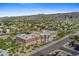 Aerial view of a neighborhood near the mountains, showcasing a large multi-story brick school at 1506 E Branham Ln, Phoenix, AZ 85042