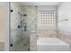 Bathroom featuring a soaking tub, frameless shower with designer tile, and modern fixtures at 1506 E Branham Ln, Phoenix, AZ 85042