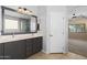 Bathroom with a large vanity and an oversized mirror is adjacent to shower and toilet room at 1506 E Branham Ln, Phoenix, AZ 85042