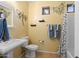 Charming bathroom with decorative elements, a pedestal sink, and a shower with a butterfly-themed curtain at 1506 E Branham Ln, Phoenix, AZ 85042