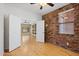 Bedroom with exposed brick wall and open doorway to main living space at 1506 E Branham Ln, Phoenix, AZ 85042