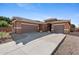 Exterior shot of a single-story home with a three-car garage and desert landscaping at 1506 E Branham Ln, Phoenix, AZ 85042