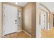 Bright foyer featuring a white entry door, wood flooring, and archway leading to the kitchen at 1506 E Branham Ln, Phoenix, AZ 85042