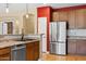 Modern kitchen featuring stainless steel appliances, tile backsplash, and wood cabinets at 1506 E Branham Ln, Phoenix, AZ 85042