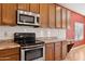 Close up of the kitchen featuring a range, microwave, and wood cabinetry at 1506 E Branham Ln, Phoenix, AZ 85042