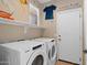 Well-equipped laundry room with modern appliances, shelving, and a fun decorative sign at 1506 E Branham Ln, Phoenix, AZ 85042