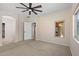 Spacious main bedroom with a ceiling fan, carpet flooring, and an ensuite bathroom at 1506 E Branham Ln, Phoenix, AZ 85042