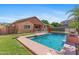 Backyard view of a refreshing pool with a safety fence, surrounded by lush green grass at 1506 E Branham Ln, Phoenix, AZ 85042