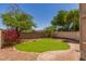 Landscaped backyard featuring a grassy area, decorative rock, and a brick patio, perfect for outdoor relaxation at 1515 E South Fork Dr, Phoenix, AZ 85048