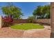 Landscaped backyard featuring a grassy area, decorative rock, and a brick patio, perfect for outdoor relaxation at 1515 E South Fork Dr, Phoenix, AZ 85048