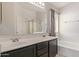 Bathroom with double sinks, black cabinetry, a shower and a soaking tub at 1515 E South Fork Dr, Phoenix, AZ 85048