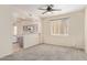 Open-concept living room with kitchen view, featuring neutral decor and a ceiling fan at 1515 E South Fork Dr, Phoenix, AZ 85048
