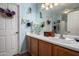 Well-lit bathroom with a double sink vanity, decorative mirrors, and ample cabinet space at 16833 N 113Th Ave, Surprise, AZ 85378