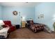 Comfortable bedroom with blue walls, cozy chair, and patterned bedding to allow for peaceful relaxation at 16833 N 113Th Ave, Surprise, AZ 85378