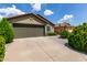 Charming home showcasing a two-car garage, manicured shrubs, and a well-maintained driveway at 16833 N 113Th Ave, Surprise, AZ 85378
