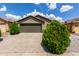 Charming home showcasing a two-car garage, manicured shrubs, and a well-maintained driveway at 16833 N 113Th Ave, Surprise, AZ 85378