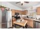 Functional kitchen featuring stainless steel appliances, oak cabinets, and a central island at 16833 N 113Th Ave, Surprise, AZ 85378