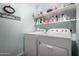 Functional laundry room equipped with washer, dryer, and ample shelving for convenient storage at 16833 N 113Th Ave, Surprise, AZ 85378