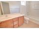 Bright bathroom features a wood vanity, a shower-tub combo, and tile floors at 1789 E Desert Breeze Pl, Casa Grande, AZ 85122