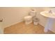 Powder room featuring tiled floors, white toilet and pedestal sink at 1789 E Desert Breeze Pl, Casa Grande, AZ 85122