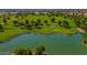 Aerial view of a scenic golf course with a tranquil lake, verdant fairways, and mature trees within a residential neighborhood at 18089 W Weatherby Dr, Surprise, AZ 85374