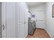 Well-equipped laundry room with white cabinets and modern washer and dryer units, ensuring efficient laundry care at 18089 W Weatherby Dr, Surprise, AZ 85374