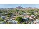 An aerial view of the residential lot with a large tree and mountain backdrop at 1909 E Bethany Home Rd, Phoenix, AZ 85016