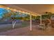 Covered patio with brick flooring and string lights, furnished with a table and chairs overlooking the backyard at 1909 E Bethany Home Rd, Phoenix, AZ 85016