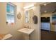 Bathroom featuring a pedestal sink, a round mirror, and a window for natural light at 1909 E Bethany Home Rd, Phoenix, AZ 85016