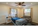 Cozy bedroom featuring a ceiling fan, natural light from two windows, and comfortable furnishings at 1909 E Bethany Home Rd, Phoenix, AZ 85016