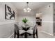 Elegant dining area with modern chandelier, glass table, and view into the kitchen at 19685 N Star Ridge Dr, Sun City West, AZ 85375