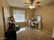 Bedroom with carpeted floors, ceiling fan, and vanity desk at 19943 N 77Th Ave, Glendale, AZ 85308