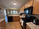 Well-lit kitchen featuring wooden cabinets, modern appliances, and hardwood floors at 19943 N 77Th Ave, Glendale, AZ 85308
