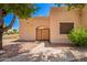 Tan single-story home with an arched gated entrance, xeriscaped yard and concrete walkway at 2019 W Lemon Tree Pl # 1185, Chandler, AZ 85224