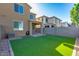 This backyard features artificial turf, a covered patio, and block wall fencing at 2254 E University Dr # 4, Mesa, AZ 85213