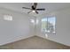 A bright, carpeted bedroom with a ceiling fan, large windows, and fresh paint at 2254 E University Dr # 4, Mesa, AZ 85213