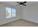 A carpeted bedroom with a ceiling fan and a large window showing the outdoor landscape at 2254 E University Dr # 4, Mesa, AZ 85213