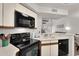 Well-maintained kitchen with black appliances, white cabinets, and a view to other living areas at 2333 E Southern Ave # 2016, Tempe, AZ 85282