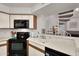Cozy kitchen features sleek black appliances, white cabinets, and an opening to the staircase at 2333 E Southern Ave # 2016, Tempe, AZ 85282