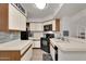 Traditional kitchen featuring wooden cabinetry, laminate countertops, and modern black appliances at 2333 E Southern Ave # 2016, Tempe, AZ 85282