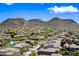 Wide aerial view of a desert community with homes nestled among mountains and desert landscape at 2638 W Sat Nam Way, Phoenix, AZ 85086
